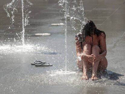  Una persona se refresca en una fuente del Parque Central de Valencia. 