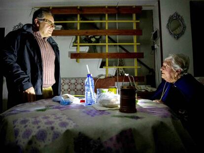 Pepa, de 94 años, residente en Almanjáyar, charla en su casa con un vecino a la luz de una linterna.