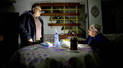 Pepa, de 94 años, residente en Almanjáyar, charla en su casa con un vecino a la luz de una linterna.