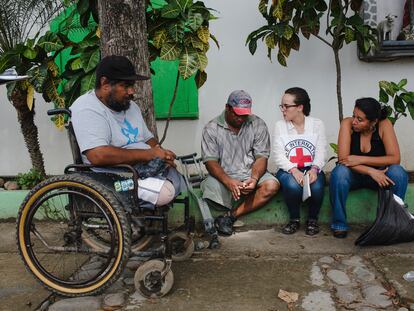 Una trabajadora de la Cruz Roja habla con migrantes en Chiapas (México).