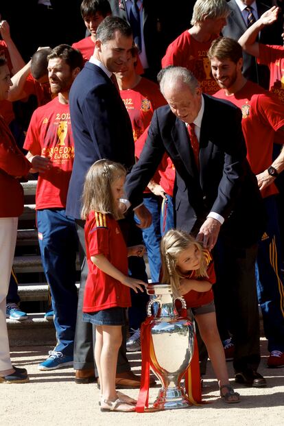 Desde niñas, las hijas de los hoy Reyes no han participado en demasiados actos oficiales, pero sí en otros de carácter más festivo e informal. Como en esta imagen, una excepción a la norma, donde las pequeñas posan con el entonces rey Juan Carlos, su abuelo, y con su padre, Felipe, en las escaleras del palacio de La Zarzuela celebrando la Eurocopa ganada por la selección española de fútbol en 2012.