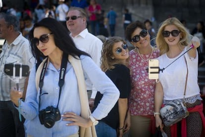 A group of tourists poses for selfies on Las Ramblas in Barcelona.
