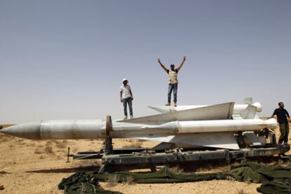 Dos rebeldes posan sobre un misil SA-5 SAM en la base de Burkan.