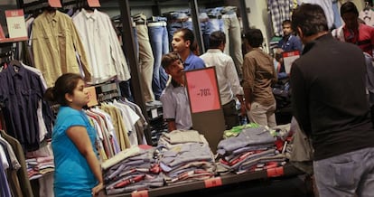 Varias personas compran ropa en una tienda de un centro comercial de Bombay. 