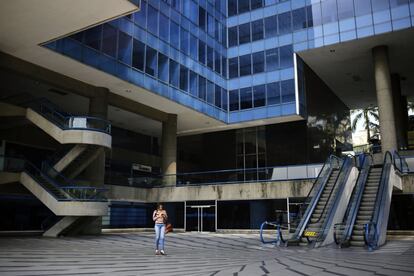 Una mujer utiliza su móvil a la salida de un centro empresarial de Caracas, cerrado por el corte de energía eléctrica que afecta al país desde la tarde del lunes. Aunque buena parte de Venezuela había ido recuperando el fluido eléctrico a última hora del martes, alrededor de las 05.00 hora local (09.00 GMT) de este miércoles, se produjo un nuevo corte generalizado, según reportaron numerosos usuarios a través de las redes sociales.