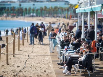 Turistas cerca de una playa en Barcelona, este lunes, a pesar del pronóstico de temporal de lluvias que había para esta Semana Santa en Cataluña.