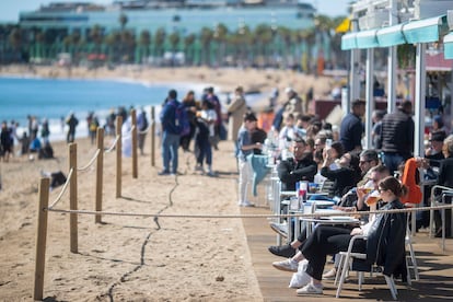 Turistas cerca de una playa en Barcelona, este lunes, a pesar del pronóstico de temporal de lluvias que había para esta Semana Santa en Cataluña.