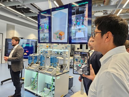 Integrantes del centro tecnológico de Siemens en el campus de investigación de la Universidad de Múnich en Garching muestran el gemelo digital de un proceso industrial.