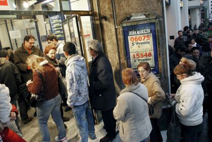 Los compradores de última hora hacen cola ante la administración de Doña Manolita en Madrid.