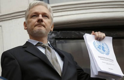 Julian Assange segura um relatório da ONU na embaixada de Equador.