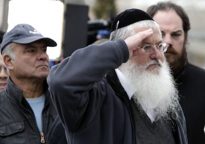 Un ciudadano israelí, ataviado con la kipá judía, saluda ante el féretro de Ariel Sharon con el saludo militar.