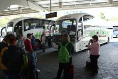 Viajeros en una de las dársenas de la Estación Sur de Autobuses de Madrid.