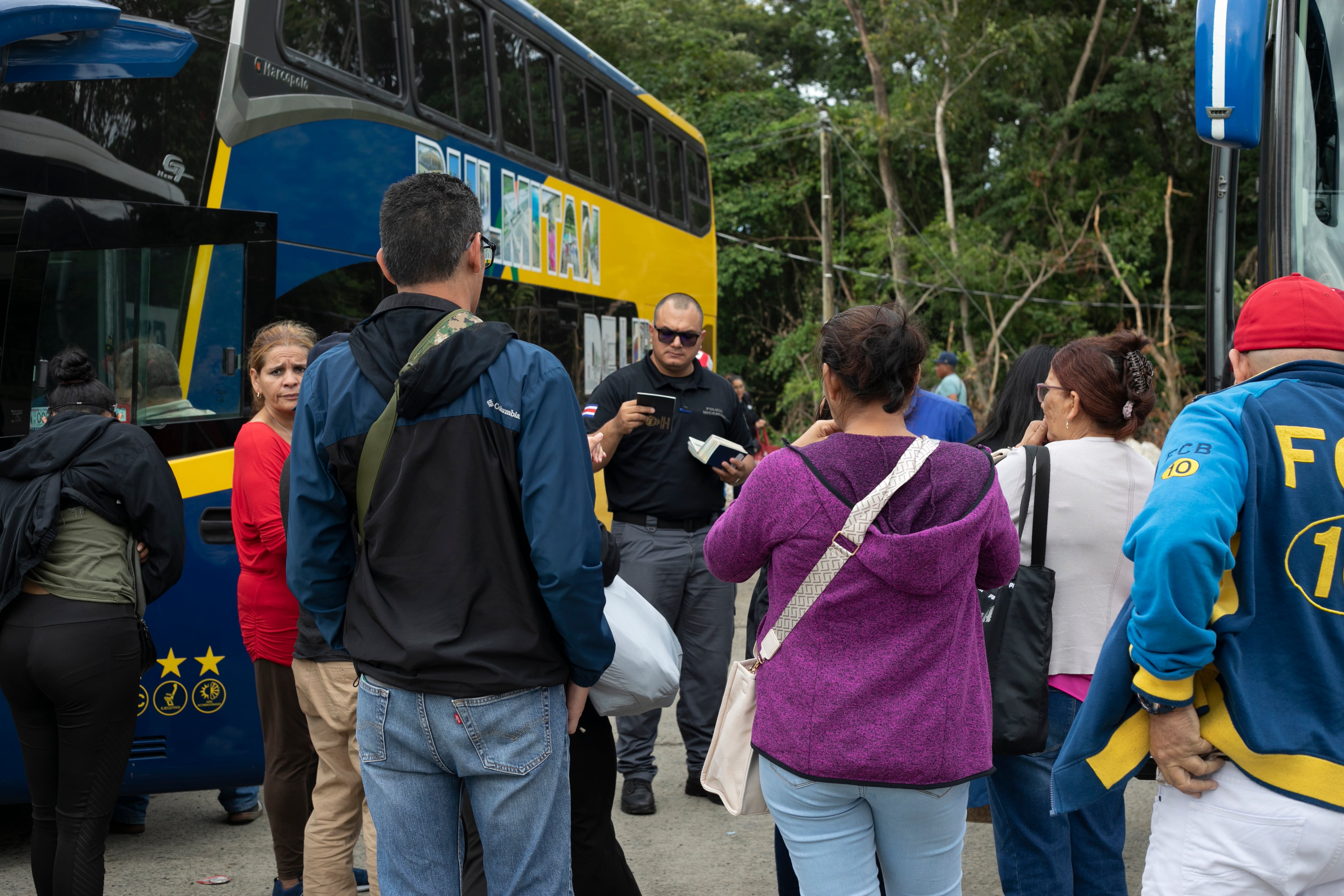 Un policía fronterizo de Costa Rica revisa pasaportes de nicaragüenses que quieren reunirse con familiares en las fiestas navideñas. 