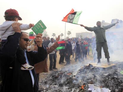 Varias personas participan en la quema de ejemplares del <i>Libro Verde</i> de Gadafi en Bengasi.