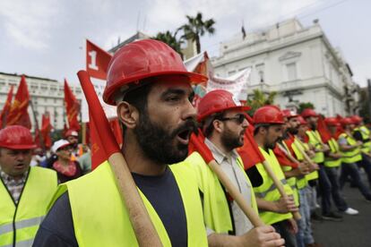 Un grupo de manifestantes con cascos de trabajo se manifiestan durante una manifestación en Atenas (Grecia).