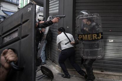 Manifestação em 2016, Rio de Janeiro, policiais sacam arma de fogo para combater manifestantes.