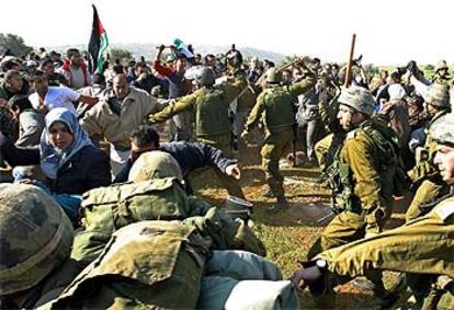 Tropas del Ejército israelí y manifestantes palestinos se enfrentan ayer en Kharbata, cerca de Ramala, por la construcción del muro de separación.