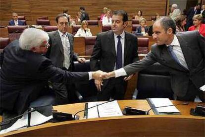 El presidente de la Generalitat, Francisco Camps (a la derecha), estrecha la mano del consejero de Transporte, José Ramón García Antón.