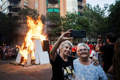 Dos mujeres se hacen un selfi durante la hoguera de Sant Joan, en el barrio de Sant Antoni, en Barcelona. 
