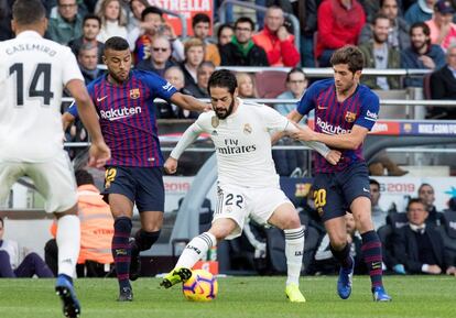 El centrocampista del Real Madrid, Isco Alarcón (c), disputa un balón ante los juagadores del FC Barcelona, el defensa Sergi Roberto (d), y el centrocampista Rafinha (i).