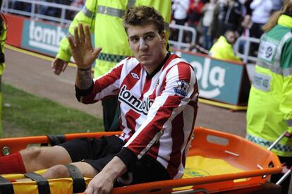 Nicklas Bendtner, jugador del Sunderland, es retirado en camilla del estadio en el partido contra el Liverpool.