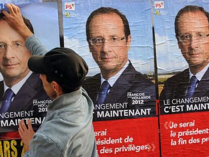 Un hombre coloca afiches electorales del candidato del partido socialista franc&eacute;s, Fran&ccedil;ois Hollande en Burdeos.