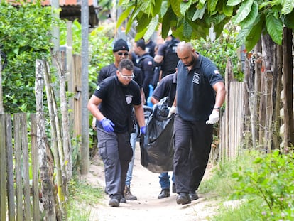 Elementos de la policía retiran un cadáver del sitio donde nueve personas fueron encontradas sin vida en Bahía, Brasil.