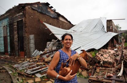 Una mujer posa con su perro frente a su casa destruida por el paso del huracán Irma en la ciudad central de Remedios (Cuba).