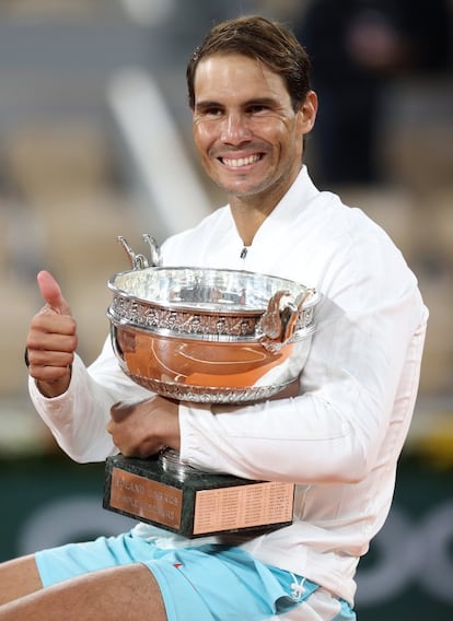 El tenista español Rafael Nadal abraza el trofeo tras su victoria ante Novak Djokovic en la final de Roland Garros.