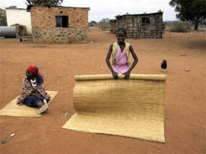 La abuela Dlamini Ntombiyembango, sentada en una esterilla, junto a una nieta en el poblado de Khushweni.