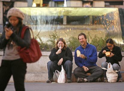 Unos turistas fotografiados ayer en la fuente de la Puerta del Sol.