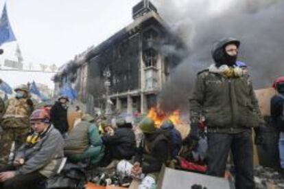 Manifestantes resisten tras la barricadas durante las protestas opositoras en el centro de Kiev.