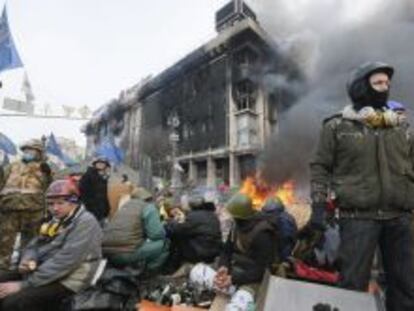 Manifestantes resisten tras la barricadas durante las protestas opositoras en el centro de Kiev.