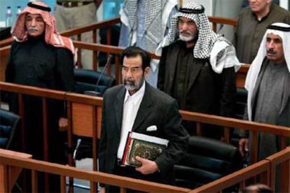 Sadam, con una copia del Corán bajo el brazo y con una chaqueta negra y una camisa blanca, al inicio de la sesión.