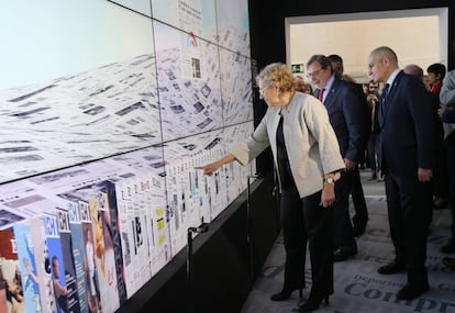 La alcaldesa de Madrid contempla una de las pantallas interactivas durante su visita a la exposición del 40º aniversario de EL PAÍS.