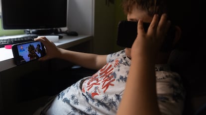 Un niño mira la pantalla de su móvil en su casa de Madrid.