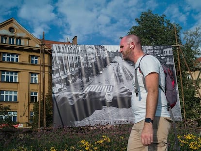 Un hombre pasa delante de una de las famosas imágenes que Koudelka tomó en 1968 situada en una calle de Praga.