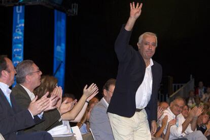 Javier Arenas responde con un saludo al caluroso aplauso de los dirigentes del PP, en un momento de la convención.