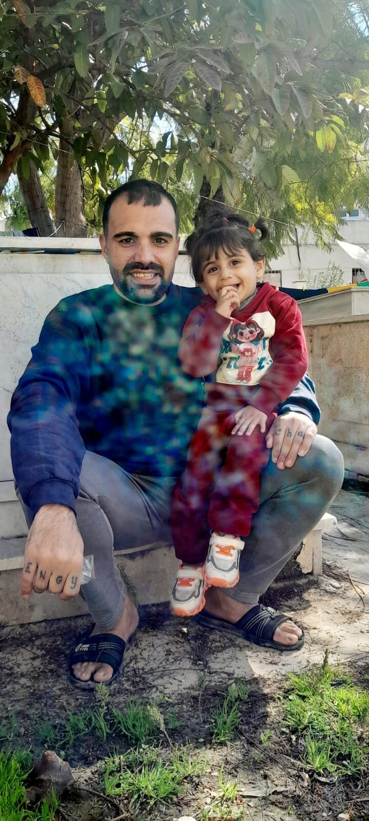 Fuad Ayyad, con su hija Lili, en el cementerio de la iglesia en Ciudad de Gaza en el que duermen en una caseta