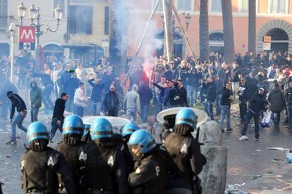 Los Policías se protegen del lanzamiento de objetos durante los enfrentamientos con los seguidores del Feyenoord en Roma