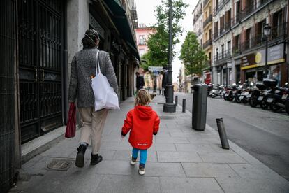 Un niño de dos años acompaña a su madre a hacer la compra, en Madrid.