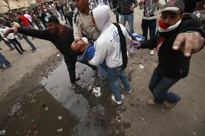 Evacuación de un manifestantes herido en los enfrentamientos con la policía cerca del Ministerio del Interior. Muchos manifestantes llevan mascarillas para protegerse de los gases lacrimógenos.