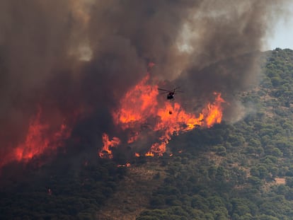 Un helicóptero cargaba agua el viernes durante las tareas de extinción del incendio en la Sierra de Mijas, en Alhaurín el Grande (Málaga).