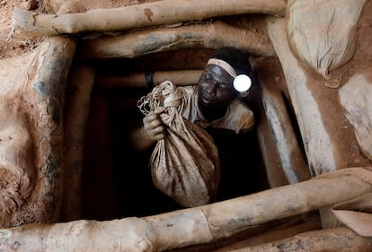 Un minero emerge de un yacimiento de oro con bolsas de rocas rotas, en Nsuaem Top, Ghana, en noviembre de 2018.