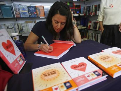 La autora del libro autoeditado 'Cree en ti', Rut Nieves, firma uno de sus ejemplares en la Feria del Libro de Madrid.