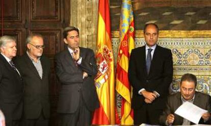 Paco Molina (CC OO) firma el acuerdo en presencia del presidente de la Generalitat, Francisco Camps, el consejero Vicente Rambla (a su lado), Rafael Ferrando (Cierval), primero por la izquierda, y Conrado Hernández (UGT).