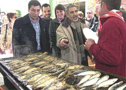 Llamazares, junto a Enrique Centella (izquierda), en la sardinada, ayer, habla con un vecino del barrio cordobés de Alcolea.