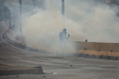 Un manifestante camina en medio de gases lacrimógenos durante los enfrentamientos con las fuerzas de seguridad en Caracas.