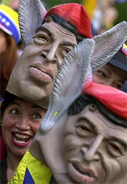 Una opositora rodeada de máscaras de Chávez con orejas de burro durante la manifestación de ayer.