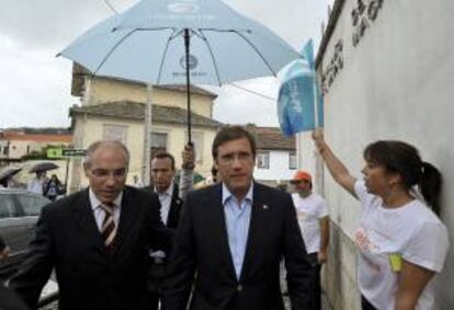 El primer ministro portugués y líder del Partido Socialdemócrata (PSD) luso, Pedro Passos Coelho (c), y el candidato del PSD para el ayuntamiento de Lamego, Francisco Lopes (i), asisten a un acto de campaña electoral para las elecciones municipales, en Lamego (Portugal), hoy, viernes 27 de septiembre de 2013.